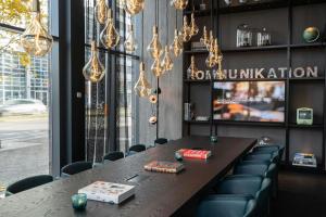a long table in a restaurant with chairs and lights at Motel One Berlin-Spittelmarkt in Berlin