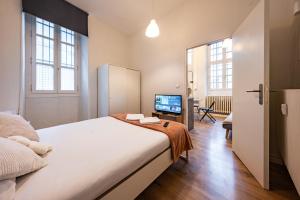 a bedroom with a large bed and a television at L'Echo de Saint-Michel - Parking Privé - StyleCosy in Dijon