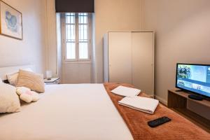 a bedroom with a large bed and a television at L'Echo de Saint-Michel - Parking Privé - StyleCosy in Dijon