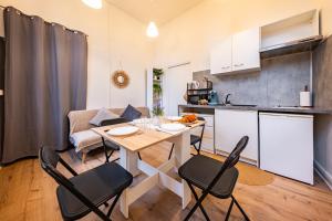 a kitchen and living room with a table and chairs at L'Echo de Saint-Michel - Parking Privé - StyleCosy in Dijon +20 photos