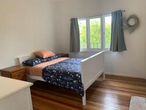 a bedroom with a bed and a window at Cobargo ButterHaus in Cobargo