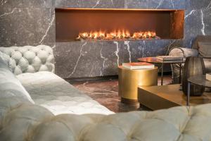 a living room with a couch and a fireplace at Motel One Berlin-Upper West in Berlin