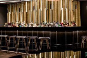 a bar with stools in a room with pipes at Motel One Berlin-Potsdamer Platz in Berlin
