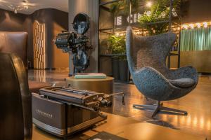 a sewing machine and a chair in a room at Motel One Berlin-Upper West in Berlin