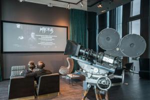 a man and a woman sitting in a room with a camera at Motel One Berlin-Upper West in Berlin