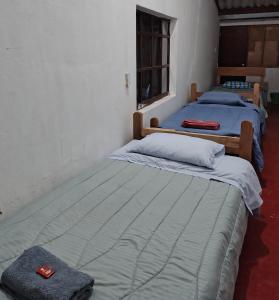 two twin beds in a room withthritisthritisthritisthritisthritisthritisthritisthritisthritis at Hostal Mama Julia - Sede Urbana - Casa Coibrí in Sibundoy