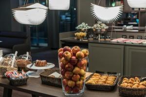 a table with a vase of apples and baskets of food at Motel One Dresden-Palaisplatz in Dresden