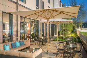 a patio with an umbrella and tables and chairs at Motel One Dresden-Palaisplatz in Dresden