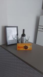 a bottle of wine and two glasses on a table at Recanto da Enseada in Guarujá