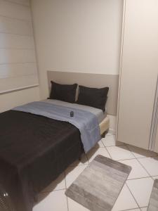 a small bed in a room with a rug at Recanto da Enseada in Guarujá