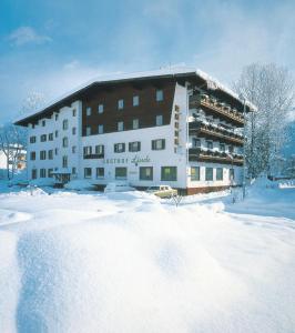 ein Gebäude im Schnee mit viel Schnee in der Unterkunft Hotel Linde in Wörgl