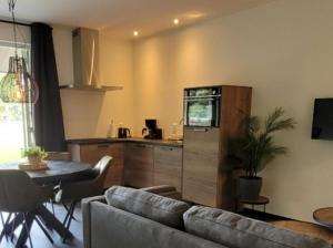 a living room with a couch and a kitchen at Timmershoeve in Vorstenbosch