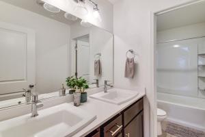 a white bathroom with two sinks and a mirror at Pool Table & Patio! Spacious Merced Getaway in Merced +30 photos