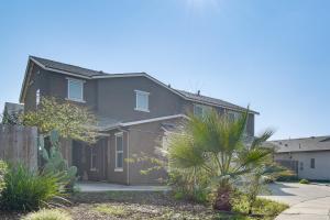 a gray house with a palm tree in front of it at Pool Table & Patio! Spacious Merced Getaway in Merced
