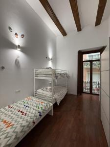 a bedroom with two bunk beds and a wooden floor at La COlectiva HOME in Xàtiva