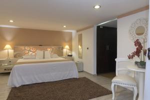 ein Schlafzimmer mit einem Bett, einem Tisch und einem Stuhl in der Unterkunft Colombe Hotel Boutique in Xalapa