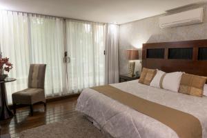 ein Schlafzimmer mit einem großen Bett und einem Stuhl in der Unterkunft Colombe Hotel Boutique in Xalapa + 57 Fotos