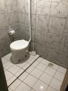 a bathroom with a toilet and a toilet paper dispenser at Casa Estrela do Mar in Conde +30 photos