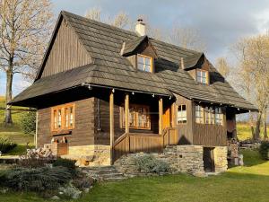 a large wooden house with a black roof at Chalúpka pod Rozsutcom in Zázrivá