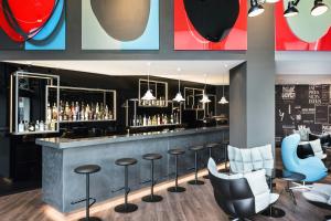 a bar in a restaurant with stools at Motel One Basel in Basel