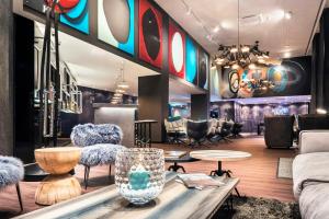a lobby with chairs and tables in a room at Motel One Basel in Basel