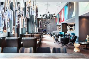a restaurant with leather chairs and a bar at Motel One Basel in Basel +23 photos
