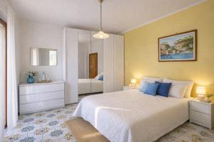 a bedroom with a large white bed and a mirror at Sorrento Life 1 in Sant'Agnello