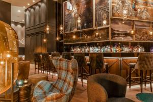 a bar with a row of stools and a bar counter at Motel One Glasgow in Glasgow