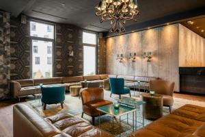 a lobby with leather furniture and a chandelier at Motel One Brussels in Brussels