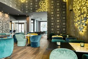 a dining room with blue chairs and tables and tablesktop at Motel One Brussels in Brussels