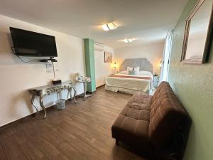 ein Hotelzimmer mit Sofa und Bett in der Unterkunft Colombe Hotel Boutique in Xalapa
