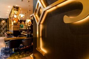 a restaurant with a bar with a table and chairs at Motel One Aachen in Aachen +33 photos