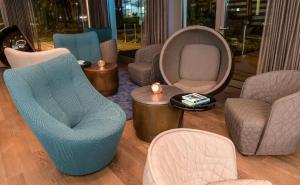 a living room with chairs and chairs and a table at Motel One München-Olympia Gate in Munich +22 photos