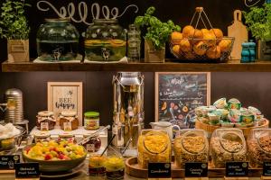 a counter with many different types of food on it at Motel One München-Sendlinger Tor in Munich +42 photos