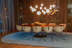 a dining room table with chairs and a chandelier at Motel One München-Olympia Gate in Munich