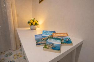 three books on a table with a vase of flowers at Sorrento Life 1 in Sant'Agnello