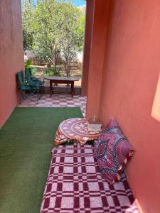 a patio with a table and pillows on a rug at Small beautiful villa in Al Massira Airport