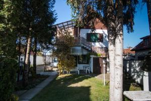 een huis met een balkon en een tuin met bomen bij Pensiunea Schneider in Covasna