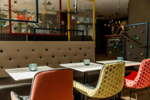 two tables in a restaurant with chairs and blue cups on them at Motel One Köln-Mediapark in Cologne
