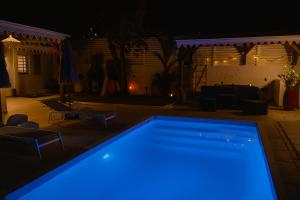 a swimming pool at night with blue lights at Appartements Des Roses in Le Lamentin
