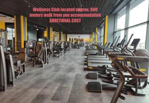 a gym with a row of treadmills and machines at Aze - Forest Whisper in Bucharest