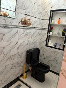 a bathroom with a black toilet and a marble wall at Small beautiful villa in Al Massira Airport +47 photos