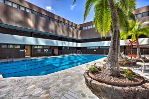 a swimming pool with a palm tree in front of a building at Free Parking Pool Harbor View Access Honolulu Gem! in Honolulu