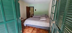 a bedroom with green doors and a bed in a room at Pousada dos Anjos in Cunha