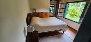 a small bedroom with a bed and a window at Pousada dos Anjos in Cunha