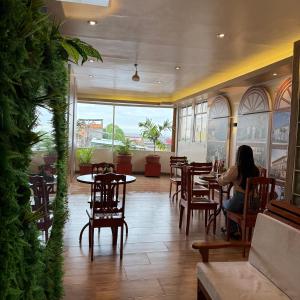 a woman sitting at a table in a restaurant at Hotel Yagua Iquitos in Iquitos