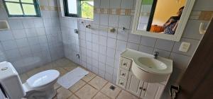 a woman taking a picture of a bathroom at Pousada dos Anjos in Cunha