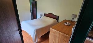 a bedroom with a bed and a wooden table at Pousada dos Anjos in Cunha +217 photos