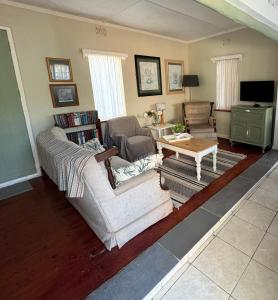 a living room with a couch and a table at Wiltshire Cottage in Port Alfred