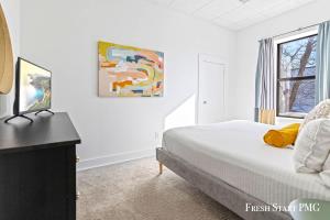 a white bedroom with a bed and a window at City View Loft in Saint Joseph